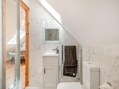 a white bathroom with a sink and a toilet at Three Gables in Kirklington