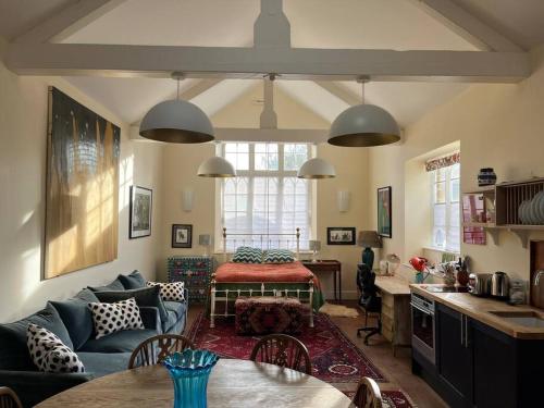 a living room with a couch and a table at Charming Old Schoolroom Studio in Daventry