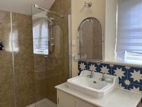 a bathroom with a sink and a shower at Charming Old Schoolroom Studio in Daventry