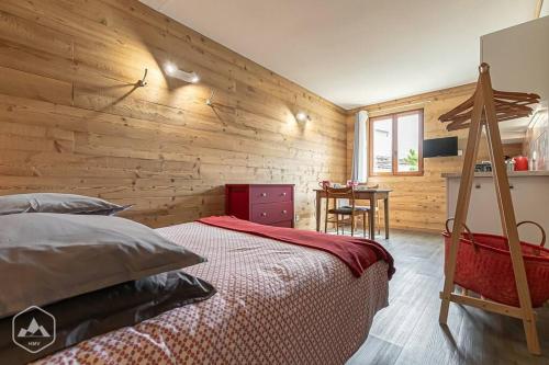 une chambre avec un lit et un mur en bois dans l'établissement Côté-Bourget 2 pers L'AIGUILLE D'ORAN proche La Norma Aussois !, à Villarodin-Bourget