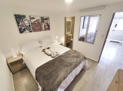 a bedroom with a bed with two towels on it at Aparta Estudio nuevo a 2 calles de Milán in Manizales
