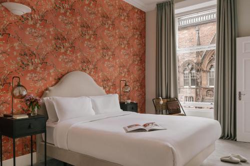 um quarto com uma cama e uma parede vermelha em Sonder Royal Garden em Edinburgo