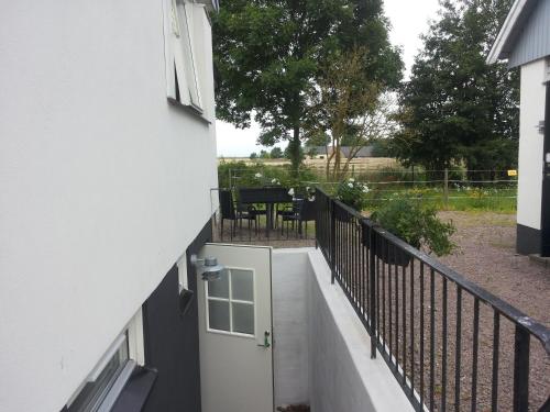 a balcony with a white door and a table at Lägenhet Lillisgården in Vallåkra