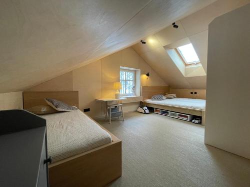 a attic room with two beds and a window at Amber bay in Juodkrantė
