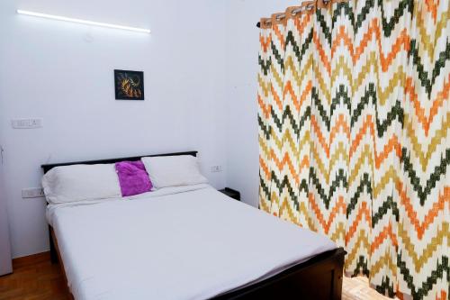 um quarto com uma cama e uma parede colorida em Seven Endue Elite em Ooty