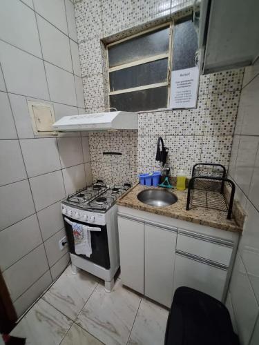 a small kitchen with a stove and a sink at Comodidade e Segurança no Centro in Belo Horizonte