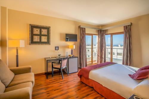 a hotel room with a bed and a desk at Hotel Andalussia in Conil de la Frontera