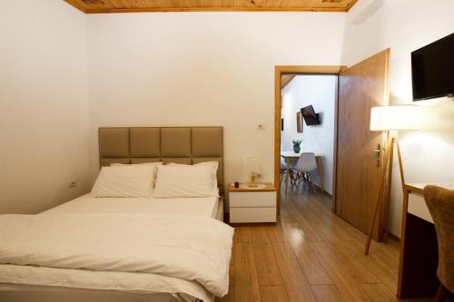 - une chambre avec un lit et une table avec une chaise dans l'établissement A&Fabio Guesthouse, à Gjirokastër