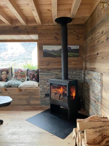 a fireplace in a log cabin with couches in a room at chalet en montagne in Lées-Athas