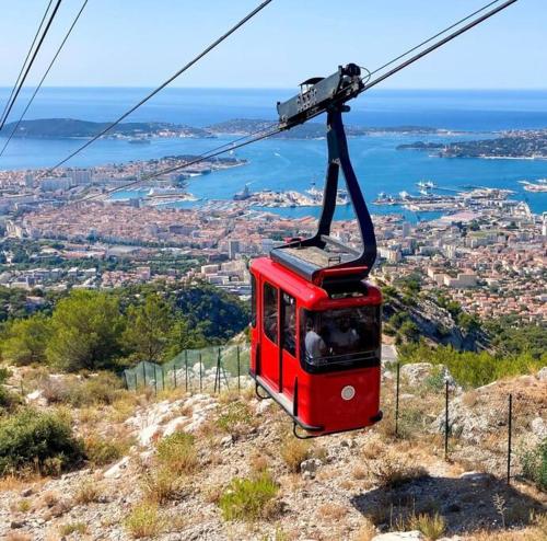 a red cable car on top of a mountain at Appartement T1 cosy neuf in Toulon