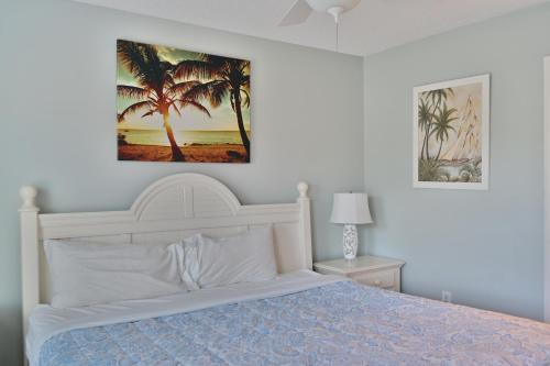 a bedroom with a white bed and palm trees at Spacious Home by the Beach 2# in Myrtle Beach