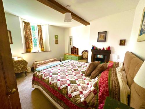 a bedroom with a bed with a quilt on it at Castle Buildings Cottage2 in Llanrhaeadr-ym-Mochnant