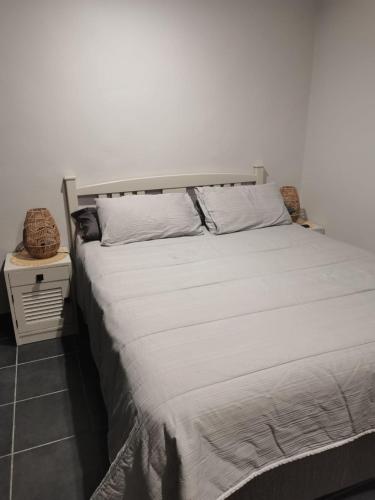 a bedroom with a large white bed with a night stand at Ruach 5 in Bellville