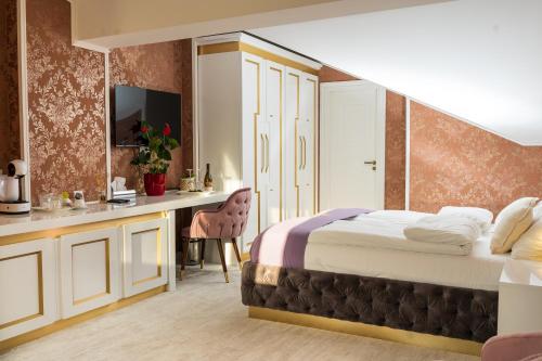 una camera d'albergo con letto e scrivania di Queen Palace a Novi Sad