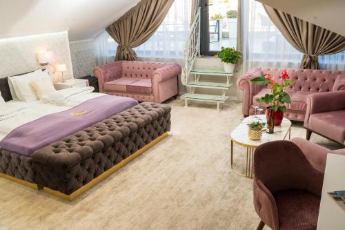 a bedroom with a bed and pink furniture at Queen Palace in Novi Sad