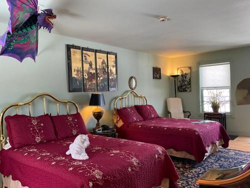 a bedroom with two beds and a white dog sitting on the bed at Mountain Quest Inn in Marlinton