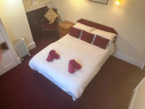 a bedroom with a bed with two red slippers on it at Kings Arms Hotel in Sandwich