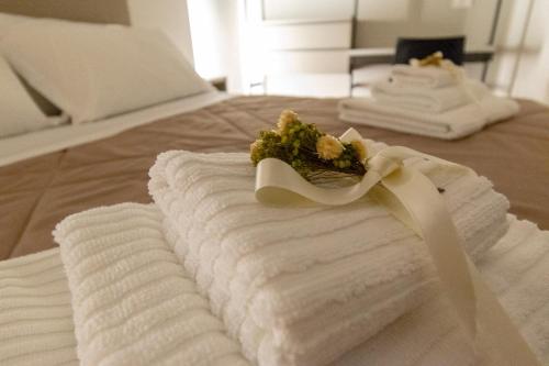 a pile of towels on a bed with a ribbon at B&B Il Mercantello in Teana