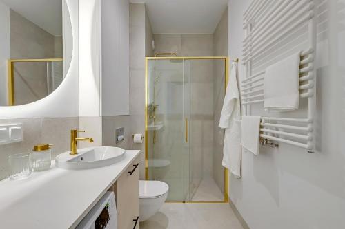 a bathroom with a toilet sink and a shower at Lazur Seven in Gdańsk