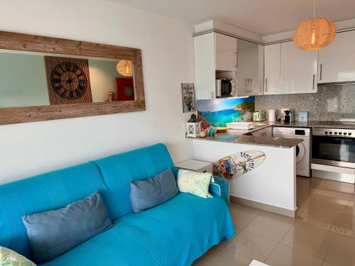 ein Wohnzimmer mit einer blauen Couch in einer Küche in der Unterkunft Almadrava Beach in Roses
