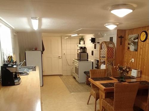 a kitchen and living room with a table and refrigerator at Dom wiejski Artur in Goldingen