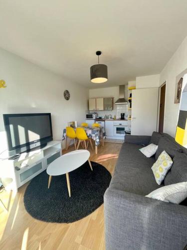 un salon avec un canapé et une table dans l'établissement Joli appartement avec parking et balcon, à Touques