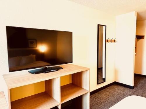 um quarto com uma grande televisão de ecrã plano numa secretária em Spark by Hilton Modesto em Modesto