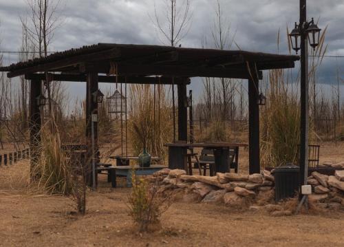 a wooden shelter with a picnic table in a field at El Madejo - del Valle de Uco in Tunuyán