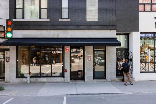 Una mujer caminando frente a una tienda en una calle en hotel & spa Carré Saint-Louis en Montreal