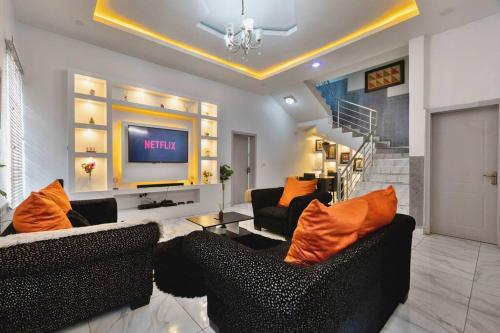 uma sala de estar com dois sofás e uma televisão em Skyfall em Lekki