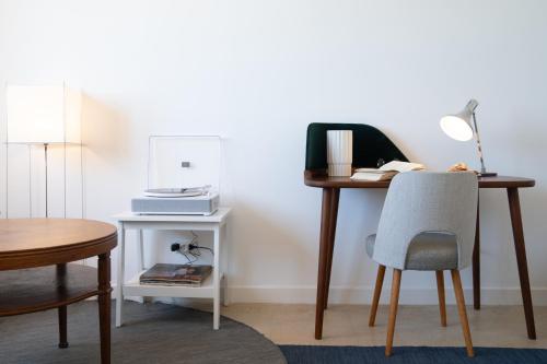 a desk with a chair and a lamp on it at Vitaminas - Casa de Playa y Café in Punta del Este