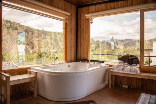 a large white tub in a room with windows at Destinos Exclusivos Patate in Patate