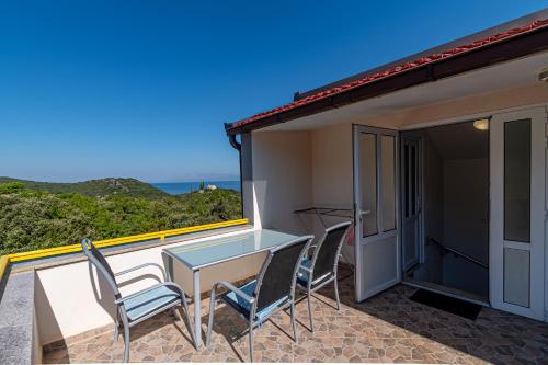 a patio with a table and chairs on a balcony at Apartment Kesten in Janjina