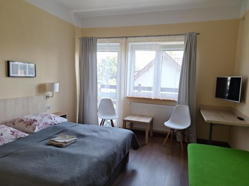 sypialnia z łóżkiem, biurkiem i oknem w obiekcie Omega Jantar w mieście Jantar