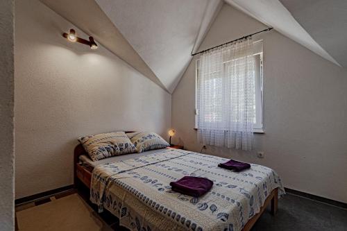 a bedroom with a bed and a window at Apartment Kesten in Janjina