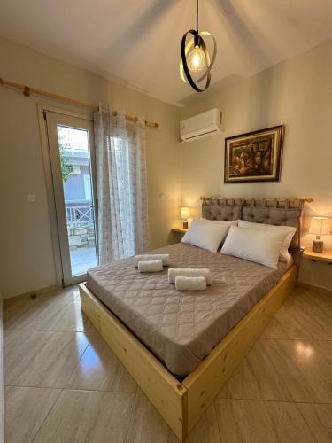 a bedroom with a large bed with two towels on it at Olea Luxury Apartment in Pythagoreio