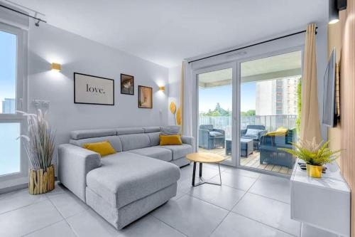 un salon avec un canapé et une grande fenêtre dans l'établissement Perle Toulousaine, à Toulouse