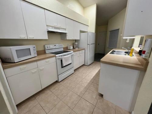 a kitchen with white cabinets and white appliances at Nice and Comfortable... in Rotunda-West