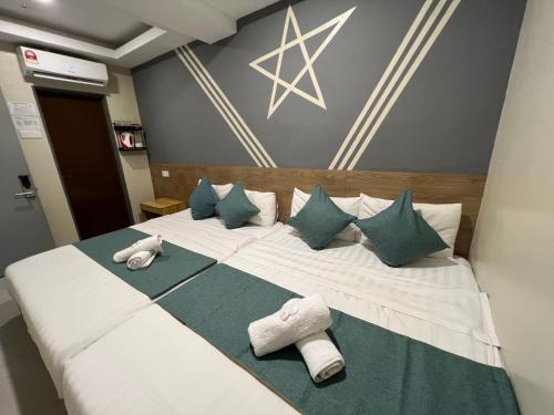 クアンタンにあるKUANTAN BESERAH BUDGET HOTELの大きな白いベッド(枕、タオル付)