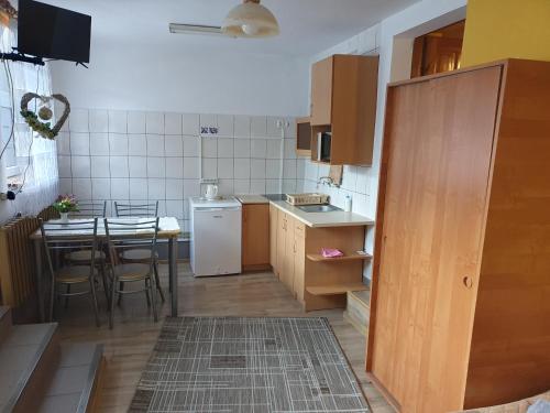 een kleine keuken met een tafel en een witte koelkast bij Pokoje Gościnne Barbara in Ustroń