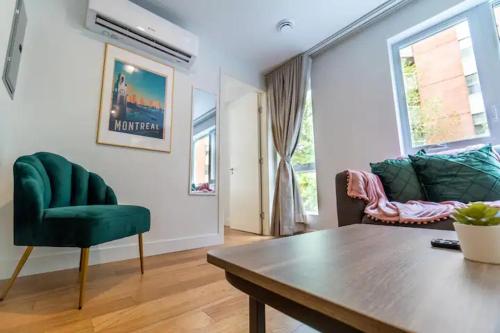 a living room with a green chair and a table at Rozenhaus Montreal Hotel in Montréal