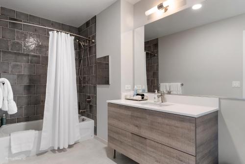 ein Badezimmer mit einem Waschbecken, einer Badewanne und einer Dusche in der Unterkunft Xl apartments at the GoldCoast- Cloud9-833 in Chicago