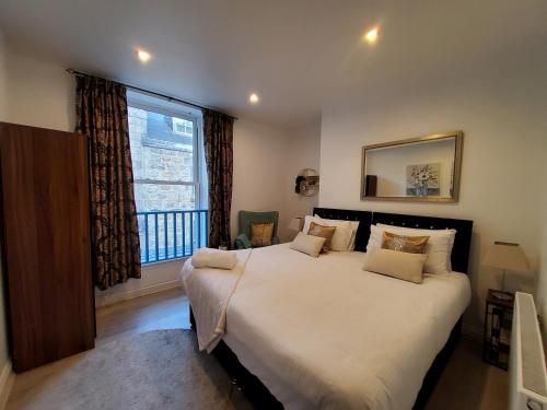 ein Schlafzimmer mit einem großen Bett und einem Fenster in der Unterkunft Adelphi Suites By Sensational Stay Short Lets & Serviced Accommodation Aberdeen City With Free Wi-fi in Aberdeen