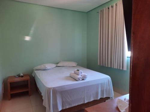 een slaapkamer met een bed met een teddybeer erop bij ELL PALACE HOTEL in Itaberaí