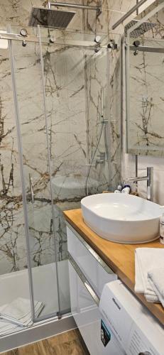 a bathroom with a sink and a shower at Apartament KRYSTIAN in Suwałki