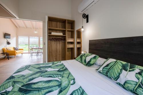 1 dormitorio con 1 cama con colcha frondosa en Apartamentos Garden Rock, en Toñanes