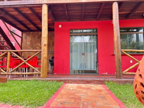 uma porta vermelha da frente de uma casa com uma parede vermelha em Chalé 3301 em Luís Correia