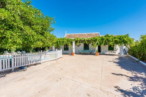 a house with a white fence and a yard at Huerta la Pimentada in Palma del Río