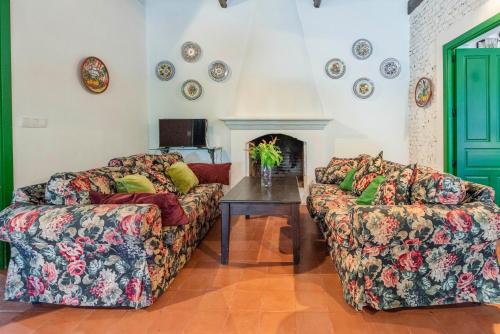 a living room with two couches and a table at Huerta la Pimentada in Palma del Río