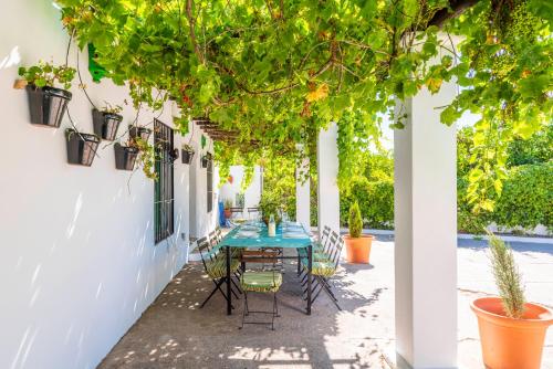 a patio with a table and chairs under a tree at Huerta la Pimentada in Palma del Río
